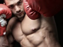 Powerful fighter punching in front of black background
